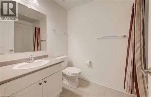 Bathroom featuring a white vanity with an integrated sink, a neutral countertop, a large wall-mounted mirror, and tile flooring - 52 Pointer Street, Cambridge, ON - Indoor Photo Showing Bathroom