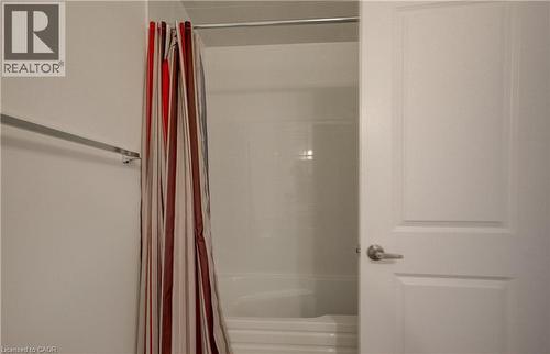 White bathtub and shower combination featuring a white surround and a chrome shower rod - 52 Pointer Street, Cambridge, ON - Indoor Photo Showing Bathroom