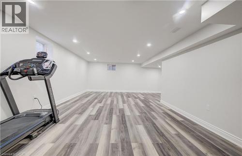 Spacious finished room featuring wood-finish flooring, recessed lighting, and white baseboards - 52 Pointer Street, Cambridge, ON - Indoor Photo Showing Gym Room