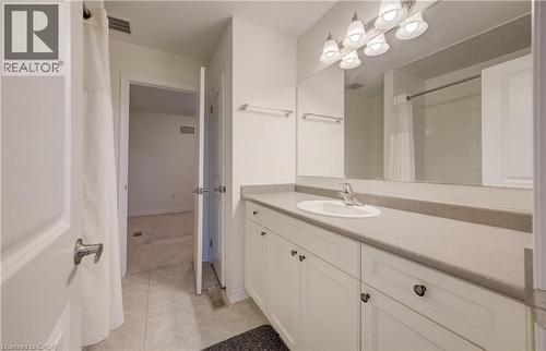 Bathroom vanity featuring an integrated sink, polished chrome faucet, and expansive mirror - 52 Pointer Street, Cambridge, ON - Indoor Photo Showing Bathroom