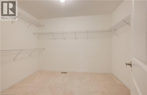 Spacious walk-in closet featuring light-colored carpeting, white walls, and built-in wire shelving - 52 Pointer Street, Cambridge, ON - Indoor With Storage