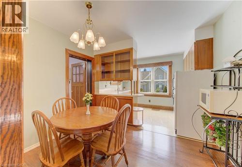Dining area featuring wood-finish flooring and a brass-toned chandelier - 224 Weber Street E, Kitchener, ON - Indoor Photo Showing Dining Room