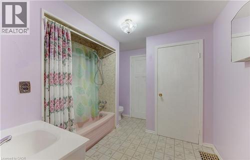 Main floor Bathroom featuring a built-in tub with an integrated shower, vanity with an undermount sink, and patterned flooring - 224 Weber Street E, Kitchener, ON - Indoor Photo Showing Bathroom