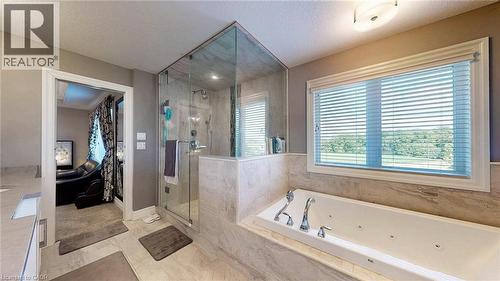 Bathroom featuring a built-in jetted tub, a glass-enclosed shower, and a large window with horizontal blinds - 537 Millstream Drive, Waterloo, ON - Indoor Photo Showing Bathroom