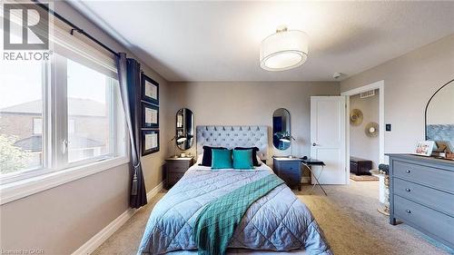 Carpeted room featuring a large window, a ceiling-mounted drum light fixture, a solid interior door, and neutral wall tones - 537 Millstream Drive, Waterloo, ON - Indoor Photo Showing Bedroom