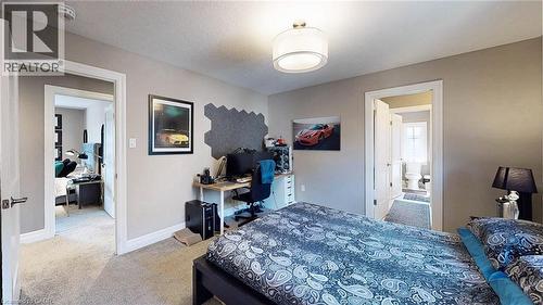 Neutral-toned walls and carpeted flooring define this room, featuring a contemporary drum pendant light fixture - 537 Millstream Drive, Waterloo, ON - Indoor Photo Showing Bedroom