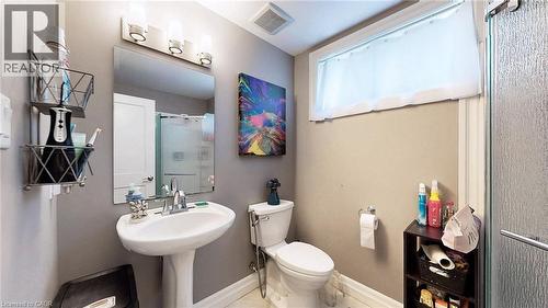 Bathroom featuring a pedestal sink, framed mirror, and a three-light vanity fixture - 537 Millstream Drive, Waterloo, ON - Indoor Photo Showing Bathroom