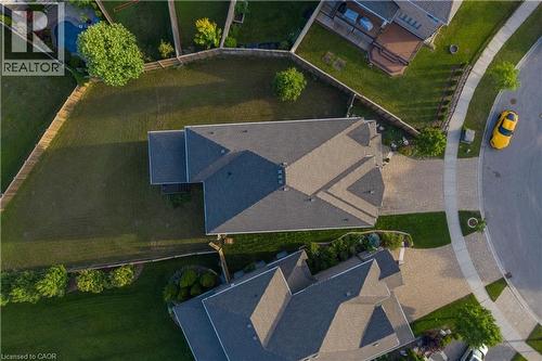 Spacious residential property featuring a large backyard, asphalt shingle roofing, paved driveway, and mature landscaping - 537 Millstream Drive, Waterloo, ON - Outdoor With View
