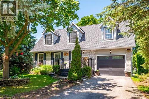 Exterior featuring a combination of light-colored stone and horizontal siding, a dark gray shingle roof, and three prominent dormer windows - 34 Peachtree Crescent, Cambridge, ON - Outdoor With Facade