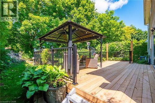 Expansive wood deck featuring a covered gazebo with string lighting, dark railings, and lush perimeter greenery - 34 Peachtree Crescent, Cambridge, ON - Outdoor With Deck Patio Veranda