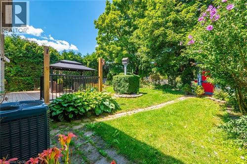 Outdoor living area featuring a wooden deck with a black metal railing, a covered gazebo, and lush perimeter greenery - 34 Peachtree Crescent, Cambridge, ON - Outdoor
