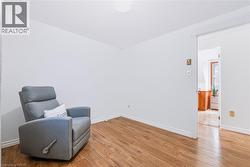 Room featuring wood-finish flooring, white baseboards, and a neutral wall palette - 