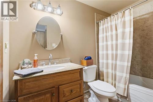 Bathroom featuring a wood vanity with a granite-style countertop, undermount sink, and chrome faucet - 46 Brett Court, Hamilton, ON - Indoor Photo Showing Bathroom