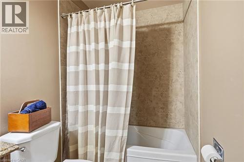 Full-size bathtub with tiled surround and warm neutral wall paint - 46 Brett Court, Hamilton, ON - Indoor Photo Showing Bathroom