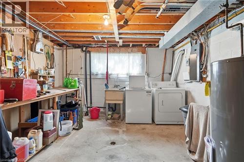 Basement utility area featuring a washer and dryer, a utility sink, exposed ceiling joists, and concrete flooring - 46 Brett Court, Hamilton, ON - Indoor Photo Showing Laundry Room