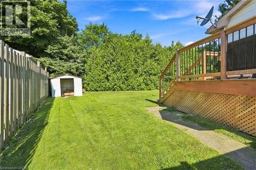 Expansive green lawn featuring a wood privacy fence, storage shed, and mature perimeter trees - 46 Brett Court, Hamilton, ON - Outdoor With Deck Patio Veranda