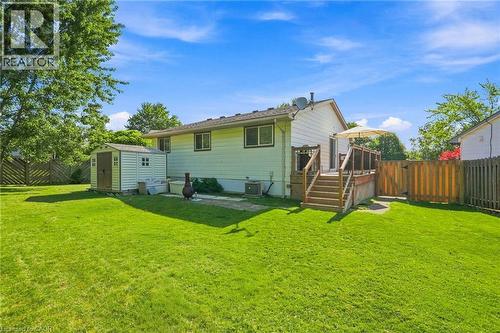 Expansive backyard featuring a manicured lawn, a raised wooden deck with railings, a privacy fence, and a storage shed - 46 Brett Court, Hamilton, ON - Outdoor