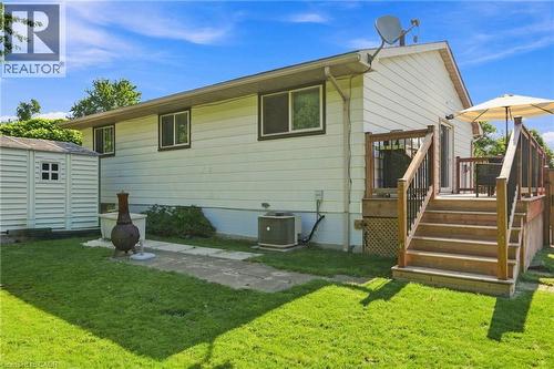 Rear exterior with a wooden deck featuring black metal balusters and stairs to the ground level - 46 Brett Court, Hamilton, ON - Outdoor With Exterior