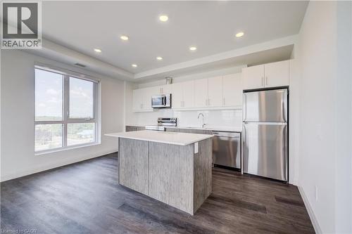 Modern kitchen featuring an island with a light-toned countertop, stainless steel appliances, white flat-panel cabinetry, a white subway tile backsplash, and recessed lighting - 1333 Weber Street E Unit# 708, Kitchener, ON - Indoor Photo Showing Kitchen With Stainless Steel Kitchen