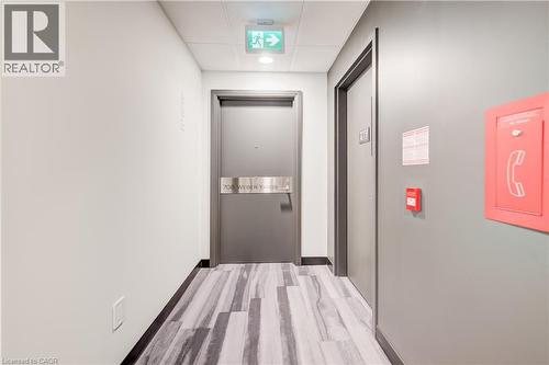 Hallway featuring a light-toned wall finish, wood-finish flooring, and recessed ceiling lighting - 1333 Weber Street E Unit# 708, Kitchener, ON - Indoor