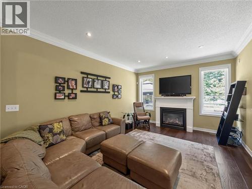 Living area featuring wood-finish flooring, recessed lighting, and crown molding - 80 Sutherland Crescent, Ancaster, ON - Indoor Photo Showing Living Room With Fireplace