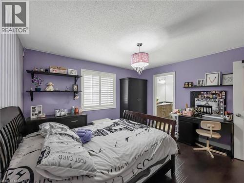 Spacious bedroom featuring lavender walls, dark wood-finish flooring, and abundant natural light from shuttered windows - 80 Sutherland Crescent, Ancaster, ON - Indoor Photo Showing Bedroom
