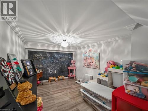 Versatile room featuring crown molding, a built-in chalkboard wall, wood-finish flooring, and recessed ceiling lighting - 80 Sutherland Crescent, Ancaster, ON - Indoor Photo Showing Other Room