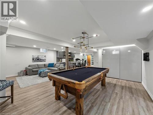 Recreation room featuring wood-finish flooring, recessed lighting, and a contemporary chandelier - 80 Sutherland Crescent, Ancaster, ON - Indoor Photo Showing Other Room