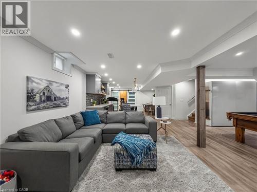 Lower-level living space featuring recessed lighting, crown molding, wood-finish flooring, and a kitchen area with a tiled backsplash - 80 Sutherland Crescent, Ancaster, ON - Indoor Photo Showing Living Room