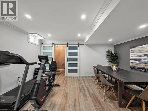 Spacious multi-purpose room featuring recessed lighting, crown molding, and wood-finish flooring - 80 Sutherland Crescent, Ancaster, ON - Indoor Photo Showing Gym Room