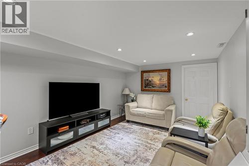 Living space featuring recessed lighting, light gray wall paint, dark wood-finish flooring, white baseboards, and a white interior door with brass hardware - 167 Berkindale Drive, Hamilton, ON - Indoor Photo Showing Living Room