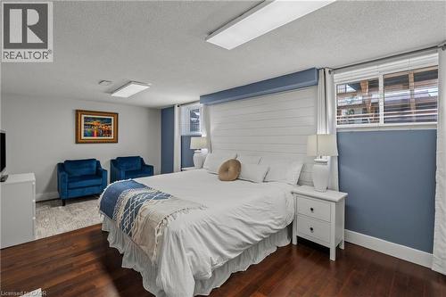 Spacious room featuring rich wood-finish flooring and a distinctive shiplap accent wall - 167 Berkindale Drive, Hamilton, ON - Indoor Photo Showing Bedroom