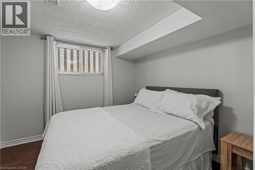 Bedroom featuring wood-finish flooring, a window with blinds, and white trim - 167 Berkindale Drive, Hamilton, ON - Indoor Photo Showing Bedroom