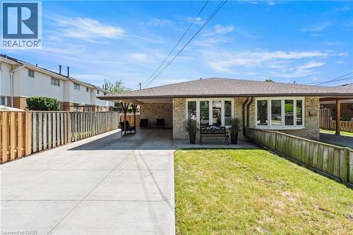 Single-story brick exterior featuring a covered carport, concrete driveway, and front lawn - 167 Berkindale Drive, Hamilton, ON - Outdoor