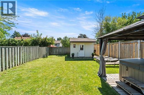 Expansive backyard featuring a manicured lawn, full perimeter wood fencing, and a detached shed - 167 Berkindale Drive, Hamilton, ON - Outdoor