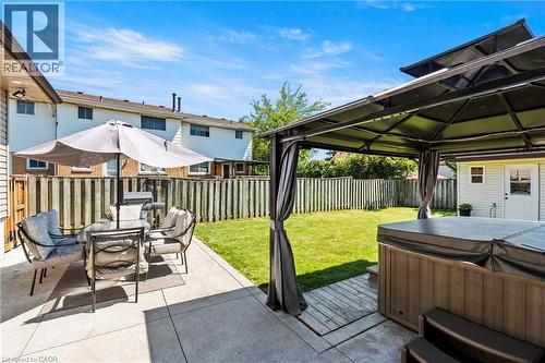 Expansive backyard featuring a concrete patio, green lawn, privacy fencing, a covered gazebo, and a built-in spa - 167 Berkindale Drive, Hamilton, ON - Outdoor With Deck Patio Veranda With Exterior