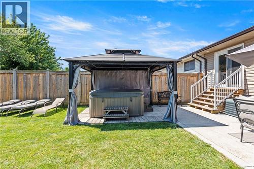 Expansive backyard featuring a hot tub under a gazebo, a concrete patio, and a manicured lawn - 167 Berkindale Drive, Hamilton, ON - Outdoor