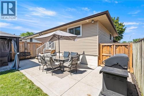Expansive concrete patio area featuring a privacy fence, a partial grass lawn, and exterior siding - 167 Berkindale Drive, Hamilton, ON - Outdoor With Deck Patio Veranda