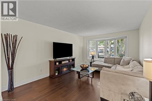 Living area featuring rich wood-finish flooring and a white baseboard trim - 167 Berkindale Drive, Hamilton, ON - Indoor Photo Showing Living Room