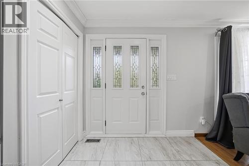 Bright foyer showcasing elegant white four-panel French doors with decorative glass inserts, complemented by crisp white cabinetry and light wood-finish flooring - 6346 Neuchatel Road, Mississauga, ON - Indoor Photo Showing Other Room