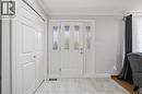 Bright foyer showcasing elegant white four-panel French doors with decorative glass inserts, complemented by crisp white cabinetry and light wood-finish flooring - 6346 Neuchatel Road, Mississauga, ON  - Indoor Photo Showing Other Room 