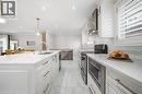 Sophisticated kitchen featuring white cabinetry with brushed metal hardware, white quartz countertops, and stainless steel appliances including a gas cooktop and built-in microwave - 6346 Neuchatel Road, Mississauga, ON  - Indoor Photo Showing Kitchen With Double Sink With Upgraded Kitchen 