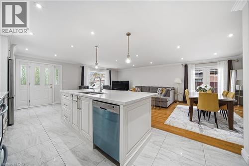 Open-concept kitchen and living area featuring a large white cabinetry island with waterfall countertop, stainless steel dishwasher, and pendant lighting - 6346 Neuchatel Road, Mississauga, ON - Indoor