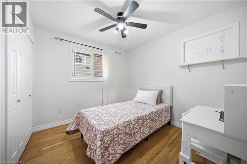 Comfortable bedroom featuring wood-finish flooring, a ceiling fan with integrated lighting, and ample natural light from a window with plantation shutters - 6346 Neuchatel Road, Mississauga, ON - Indoor Photo Showing Bedroom