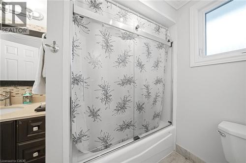 Modern full bathroom featuring a sliding glass shower enclosure with decorative frosted patterning, white subway tile surround, and chrome fixtures - 6346 Neuchatel Road, Mississauga, ON - Indoor Photo Showing Bathroom
