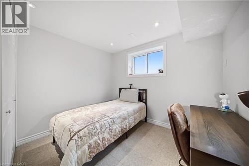 Bright bedroom featuring a large operable window with abundant natural light, wood-finish flooring, recessed ceiling lighting, and a wood-grain desk with integrated storage - 6346 Neuchatel Road, Mississauga, ON - Indoor Photo Showing Bedroom