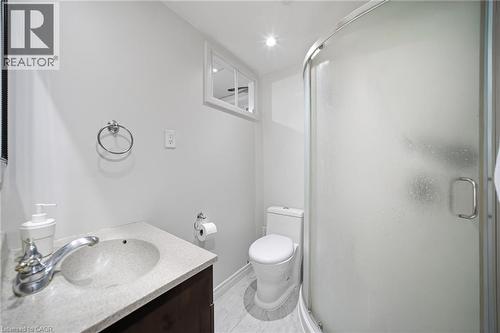Bathroom featuring a corner shower with frosted glass, a single vanity with a light-colored countertop, and a white toilet - 6346 Neuchatel Road, Mississauga, ON - Indoor Photo Showing Bathroom