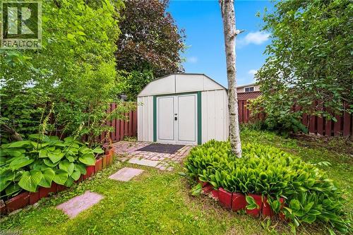 Backyard retreat featuring a modern metal storage shed with clean-lined architecture, positioned on a paved stepping-stone pathway - 6346 Neuchatel Road, Mississauga, ON - Outdoor