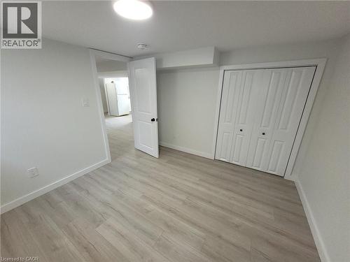 Spacious bedroom featuring pristine drywall finishes, wood-finish flooring throughout, and abundant natural light from recessed ceiling fixtures - 132 East 31St Street, Hamilton, ON - Indoor Photo Showing Other Room