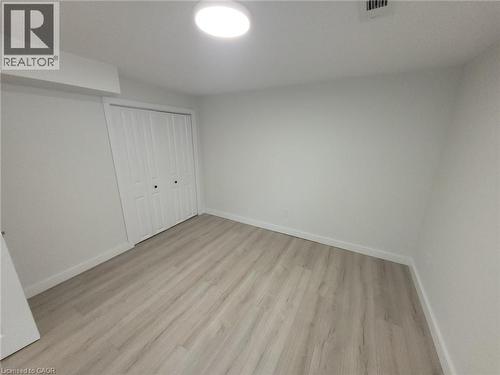 Room featuring light wood-finish flooring, white walls, and a bi-fold closet with black hardware - 132 East 31St Street, Hamilton, ON - Indoor Photo Showing Other Room